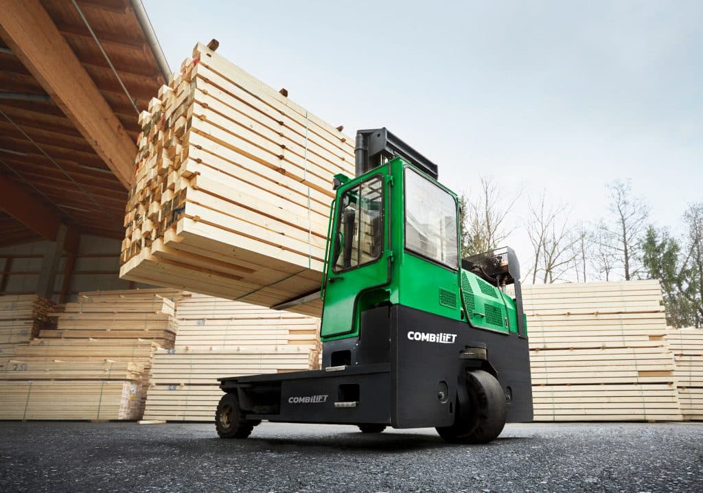 Combilift C-Series multi-directional forklift carrying a long load of engineered lumber in an outdoor timber yard
