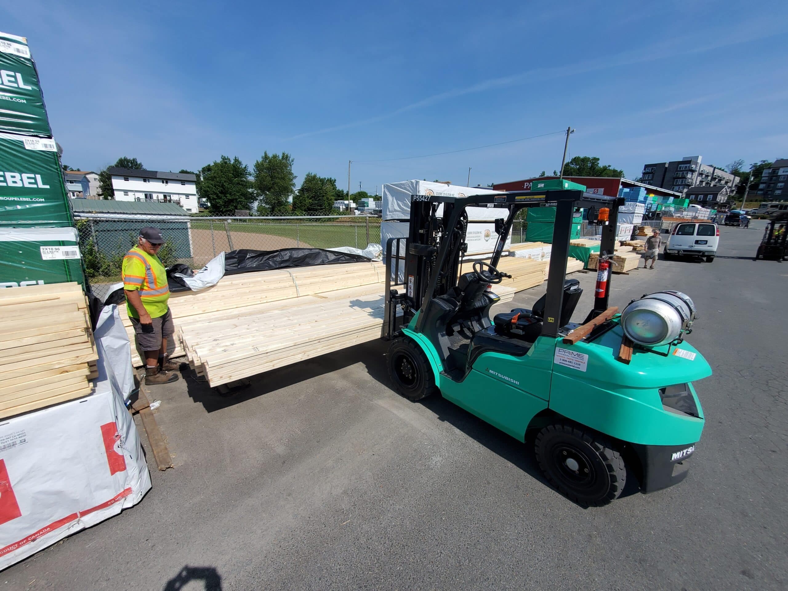 A Prime Material Handling forklift loading lumber at a customer yard
